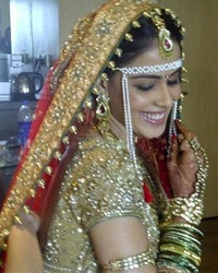 Genelia's bridal saree is a red traditional saree with a Golden blouse.