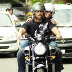 John Abraham riding his Yamaha VMax on Mumbai's roads. A Radio Jockey is riding pillion with him.