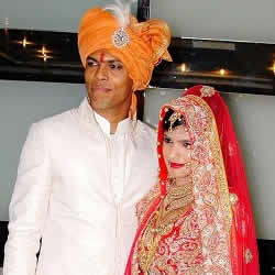 Wedding picture of Bowler Umesh Yadav in a Sherwani and wife, Tanya, in a red Bridal Chagra Choli.